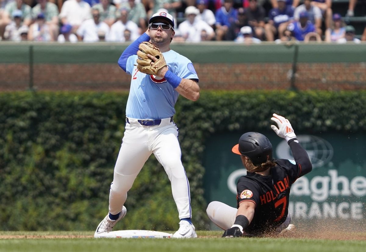 Aug 1, 2025; Chicago, Illinois, USA;  Chicago Cubs second base Nico Hoerner (2) forces out Baltimore Orioles second base Jackson Holliday (7) at second base during the third inning at Wrigley Field. Mandatory Credit: David Banks-Imagn Images