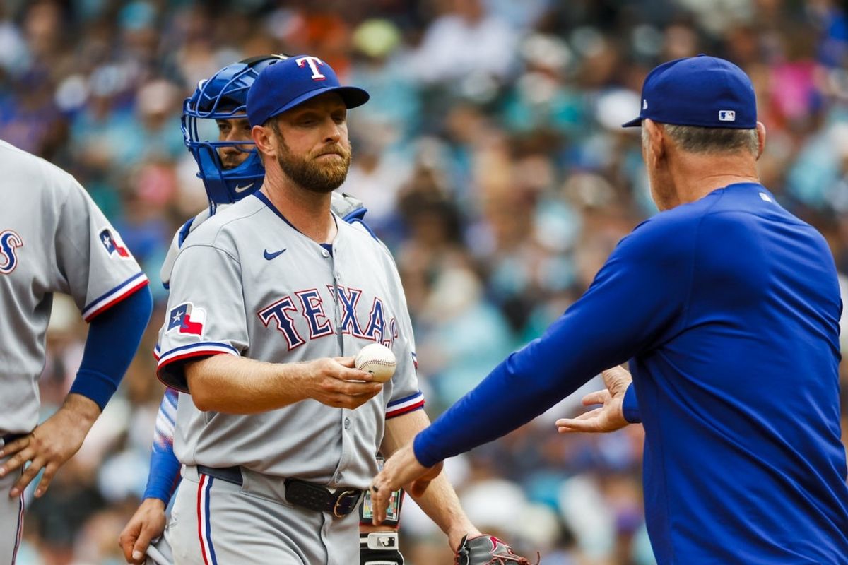 Aug 2, 2025; Seattle, Washington, USA; Texas Rangers starting pitcher Merrill Kelly (23) hands over the ball to manager Bruce Bochy (15) during a sixth inning pitching change against the Seattle Mariners at T-Mobile Park. Mandatory Credit: Joe Nicholson-Imagn Images