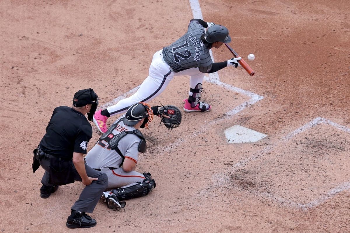 Aug 2, 2025; New York City, New York, USA; New York Mets shortstop Francisco Lindor (12) bunts for an RBI single against the San Francisco Giants during the fourth inning at Citi Field. Mandatory Credit: Brad Penner-Imagn Images