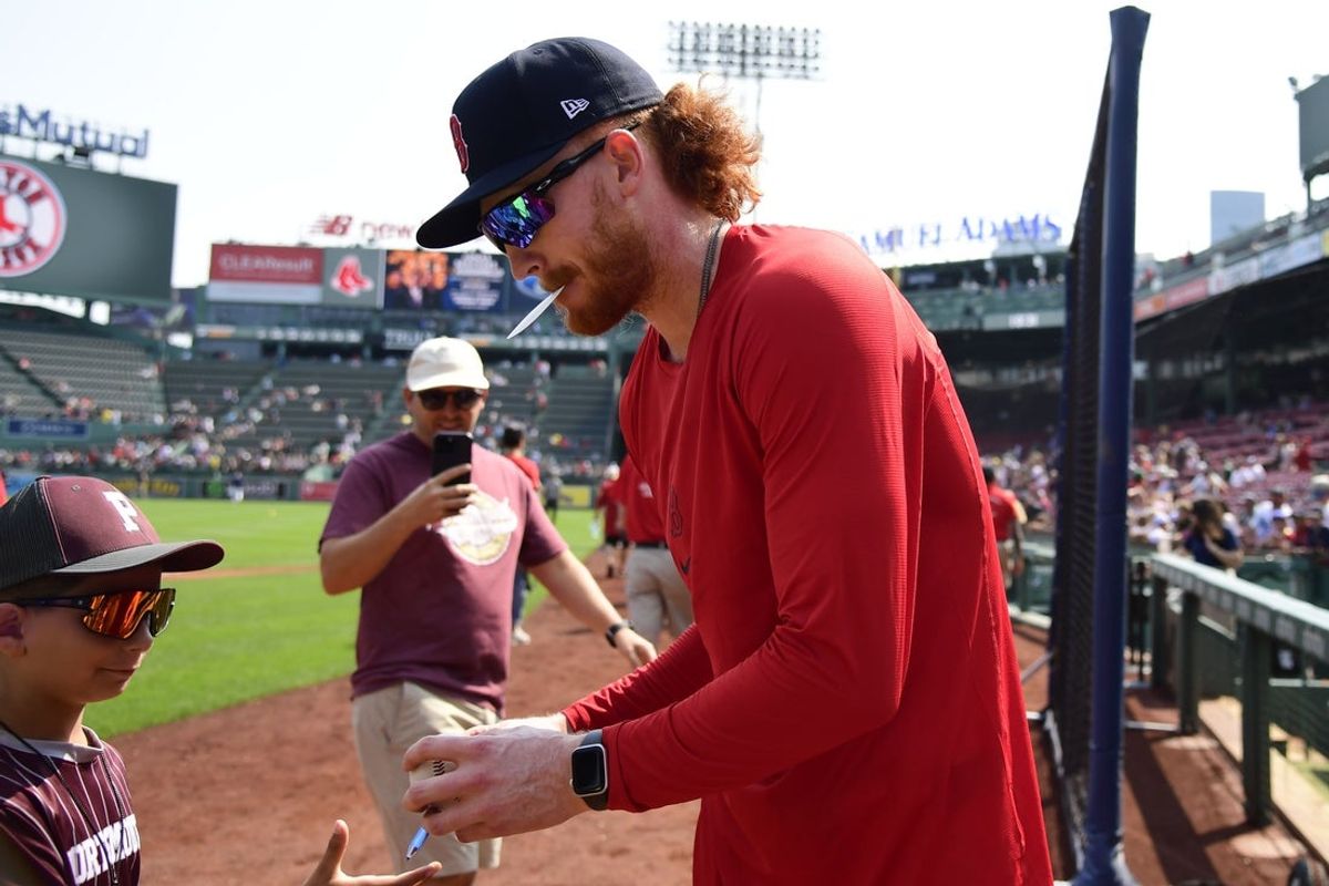 Aug 3, 2025; Boston, Massachusetts, USA;  Newly acquired pitcher Boston Redsox pitcher Dustin May signed an autograph prior to a game against the Houston Astros at Fenway Park. Mandatory Credit: Bob DeChiara-Imagn Images