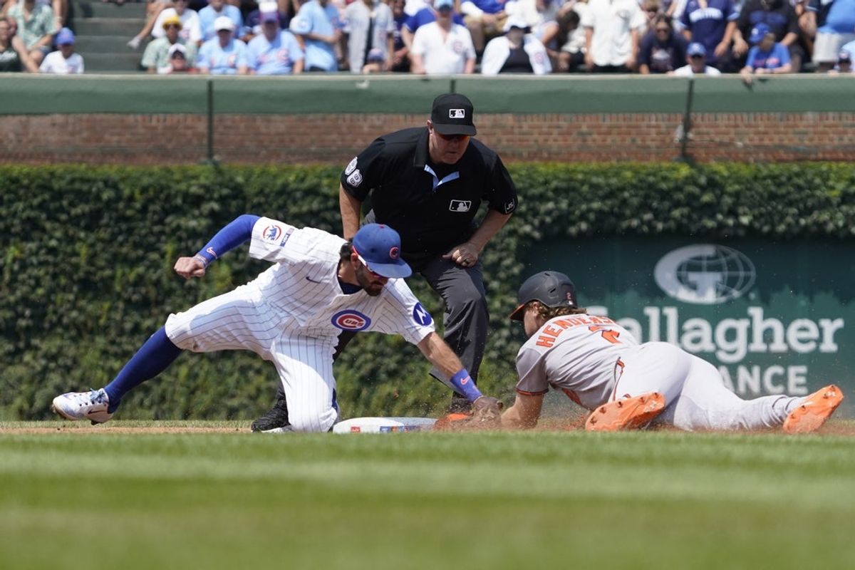 Aug 3, 2025; Chicago, Illinois, USA; Chicago Cubs shortstop Dansby Swanson (7) tags out Baltimore Orioles shortstop Gunnar Henderson (2) at second base during the third inning at Wrigley Field. Mandatory Credit: David Banks-Imagn Images