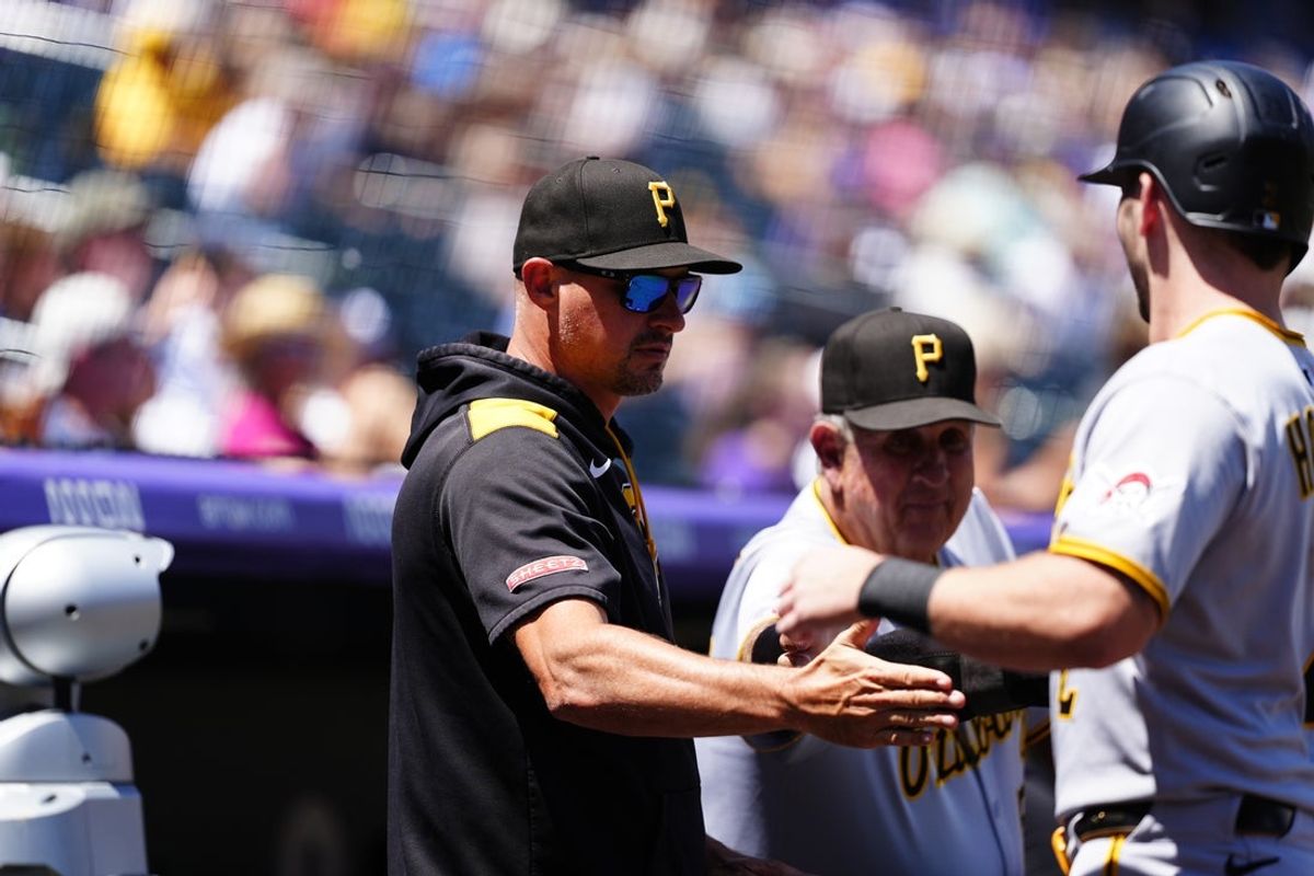 Aug 3, 2025; Denver, Colorado, USA; Pittsburgh Pirates manager Don Kelly (12) shakes the hand of Pittsburgh Pirates first baseman Spencer Horwitz (2) in the first inning at Coors Field. Mandatory Credit: Ron Chenoy-Imagn Images