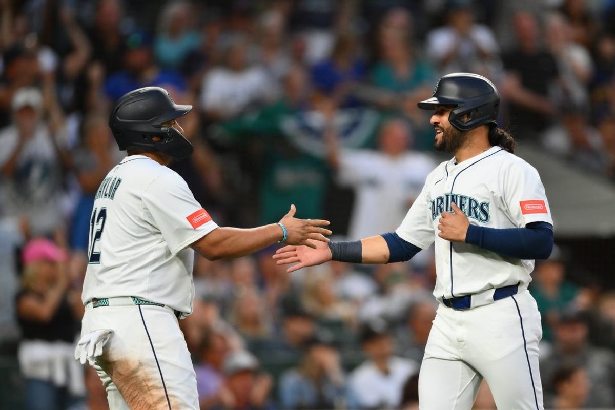 Aug 5, 2025; Seattle, Washington, USA; Seattle Mariners first baseman Josh Naylor (12) and third baseman Eugenio Suarez (28) celebrate after both scored a run against the Chicago White Sox during the sixth inning at T-Mobile Park. Mandatory Credit: Steven Bisig-Imagn Images