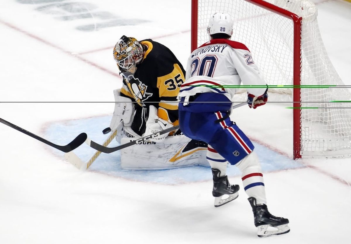 Jan 27, 2024; Pittsburgh, Pennsylvania, USA;  Pittsburgh Penguins goaltender Tristan Jarry (35) makes a save against Montreal Canadiens left wing Juraj Slafkovsky (20) in overtime at PPG Paints Arena. The Penguins won 3-2 in overtime.