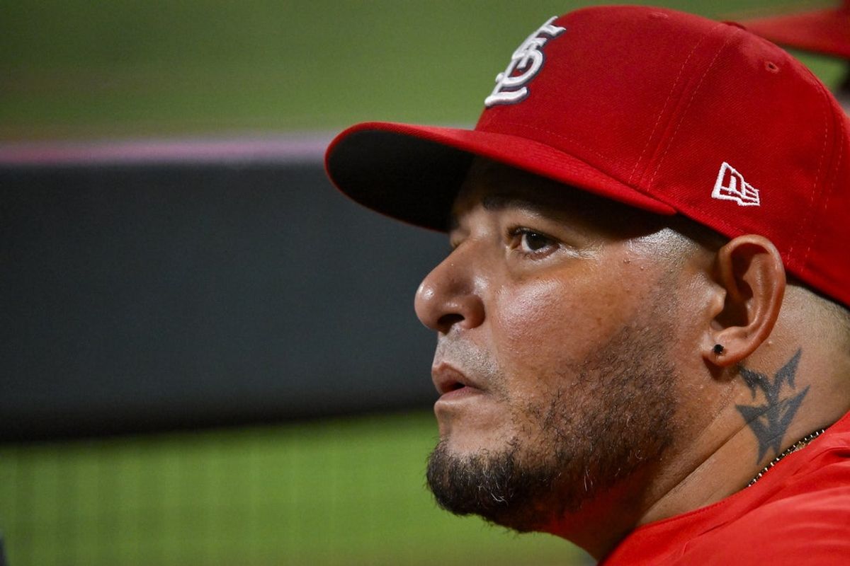 Aug 9, 2025; St. Louis, Missouri, USA;  St. Louis Cardinals guest coach Yadier Molina (4) looks on from the dugout during the ninth inning against the Chicago Cubs at Busch Stadium. Mandatory Credit: Jeff Curry-Imagn Images