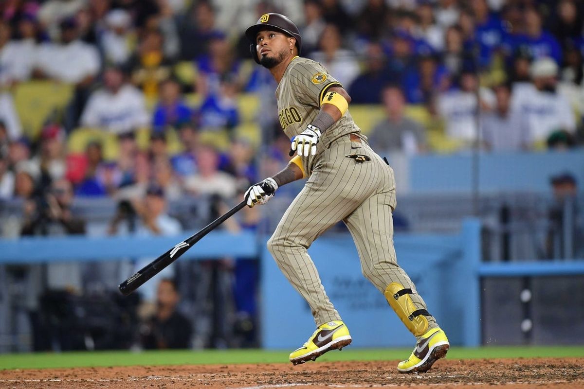 Aug 15, 2025; Los Angeles, California, USA; San Diego Padres first baseman Luis Arraez (4) hits a sacrifice RBI against the Los Angeles Dodgers during the eighth inning at Dodger Stadium. Mandatory Credit: Gary A. Vasquez-Imagn Images
