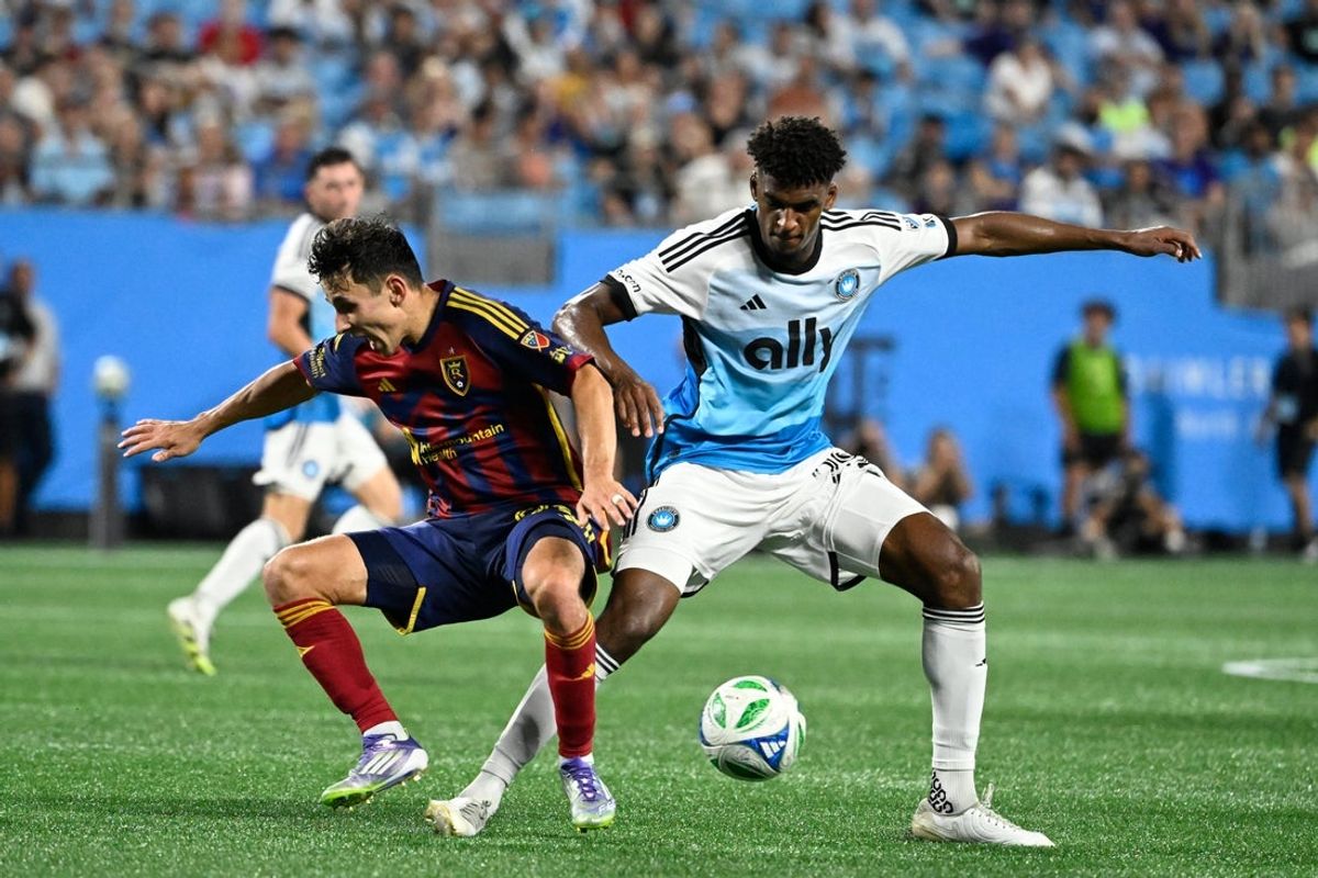 Aug 16, 2025; Charlotte, North Carolina, USA;  Real Salt Lake midfielder Noel Caliskan (92) and Charlotte FC defender Adilson Malanda (29) fight for the ball in the second half at Bank of America Stadium. Mandatory Credit: Bob Donnan-Imagn Images