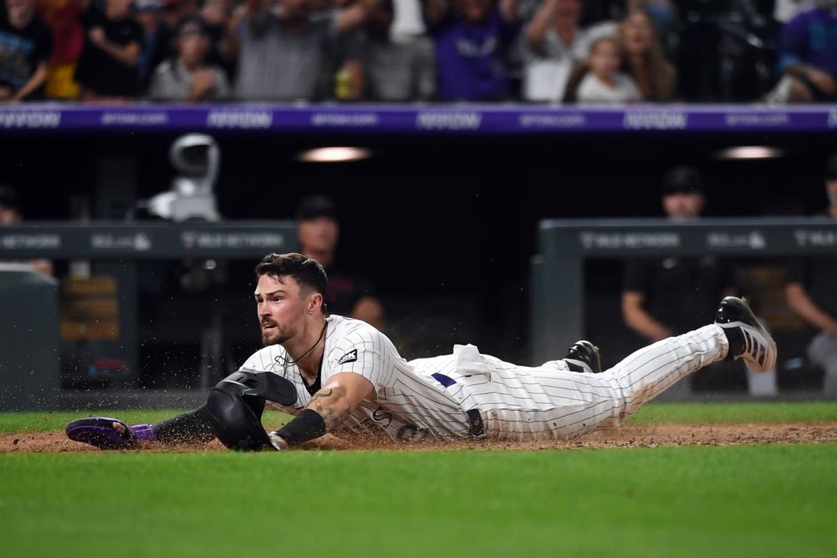 Aug 16, 2025; Denver, Colorado, USA; Colorado Rockies outfielder Brenton Doyle (9) slides safely into home ahead of the tag by Arizona Diamondbacks catcher Adrian Del Castillo (not pictured) during the eighth inning at Coors Field. Mandatory Credit: Christopher Hanewinckel-Imagn Images