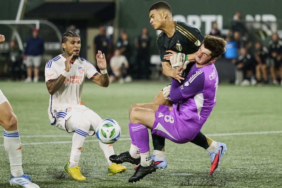 Aug 16, 2025; Portland, Oregon, USA; Portland Timbers forward Kevin Kelsy (19) crashes into FC Cincinnati goalkeeper Roman Celentano (18) during the second half at Providence Park. Mandatory Credit: Troy Wayrynen-Imagn Images