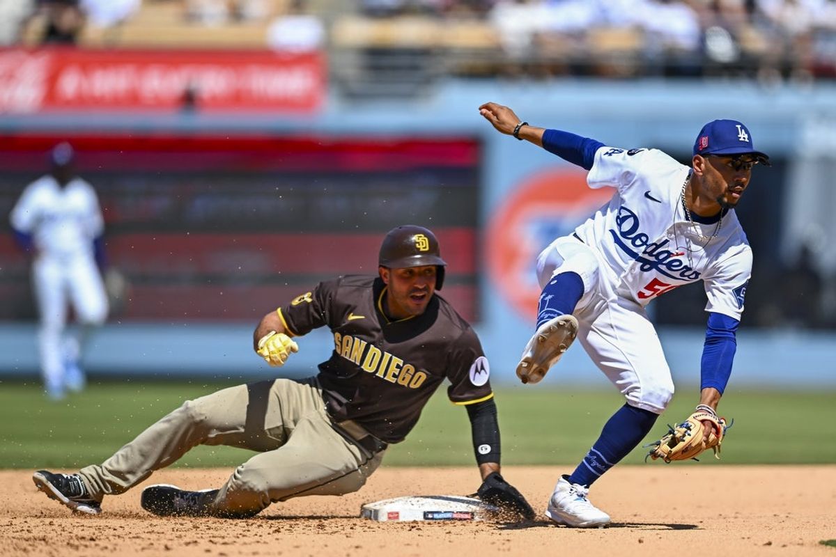 Aug 17, 2025; Los Angeles, California, USA; San Diego Padres outfielder Ramón Laureano (5) slides into second base against Los Angeles Dodgers shortstop Mookie Betts (50) during the sixth inning at Dodger Stadium. Mandatory Credit: Jonathan Hui-Imagn Images