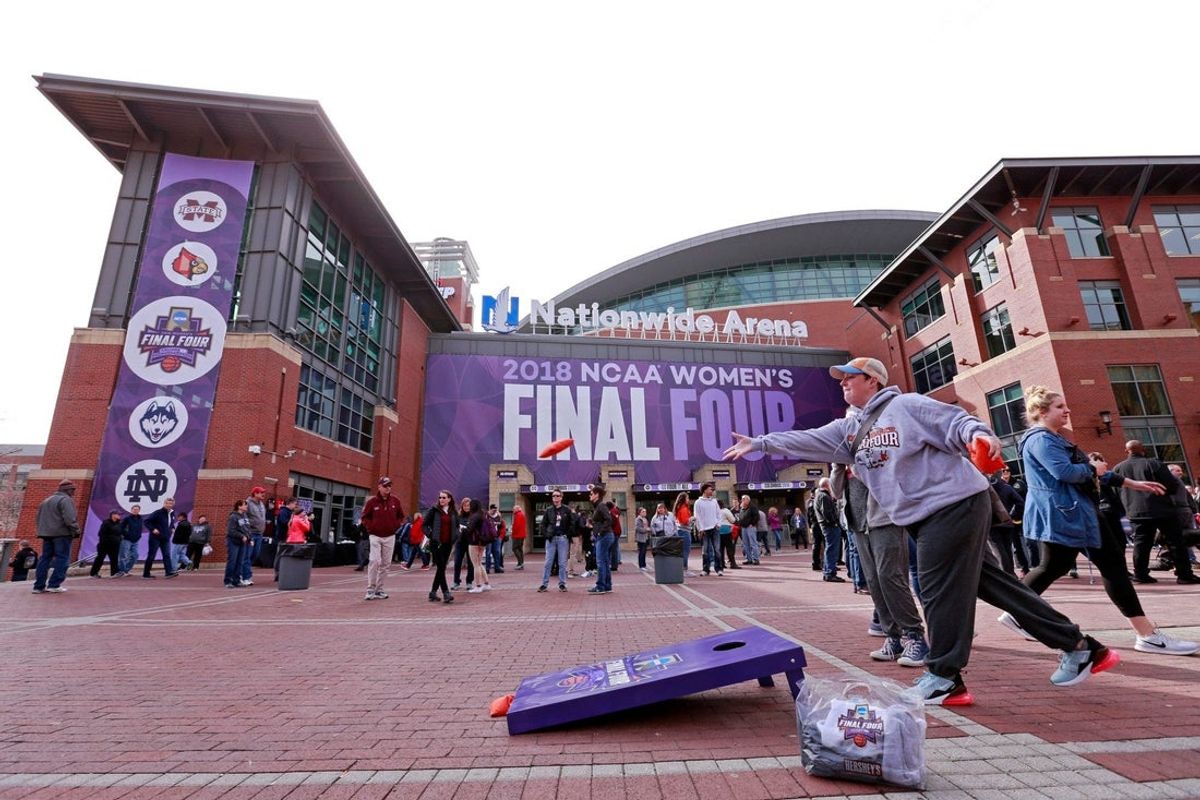 Basketball fans enjoy a game of cornhole during Party on the Plaza outside Nationwide Arena before the NCAA women's Final Four semifinal basketball gamse in Columbus on Friday, March 30, 2018. [Barbara J. Perenic/Dispatch]