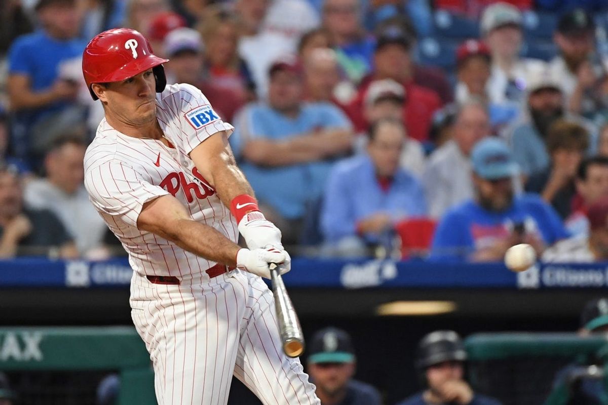 Aug 19, 2025; Philadelphia, Pennsylvania, USA; Philadelphia Phillies catcher J.T. Realmuto (10) hits an RBI single during the third inning against the Seattle Mariners  at Citizens Bank Park. Mandatory Credit: Eric Hartline-Imagn Images
