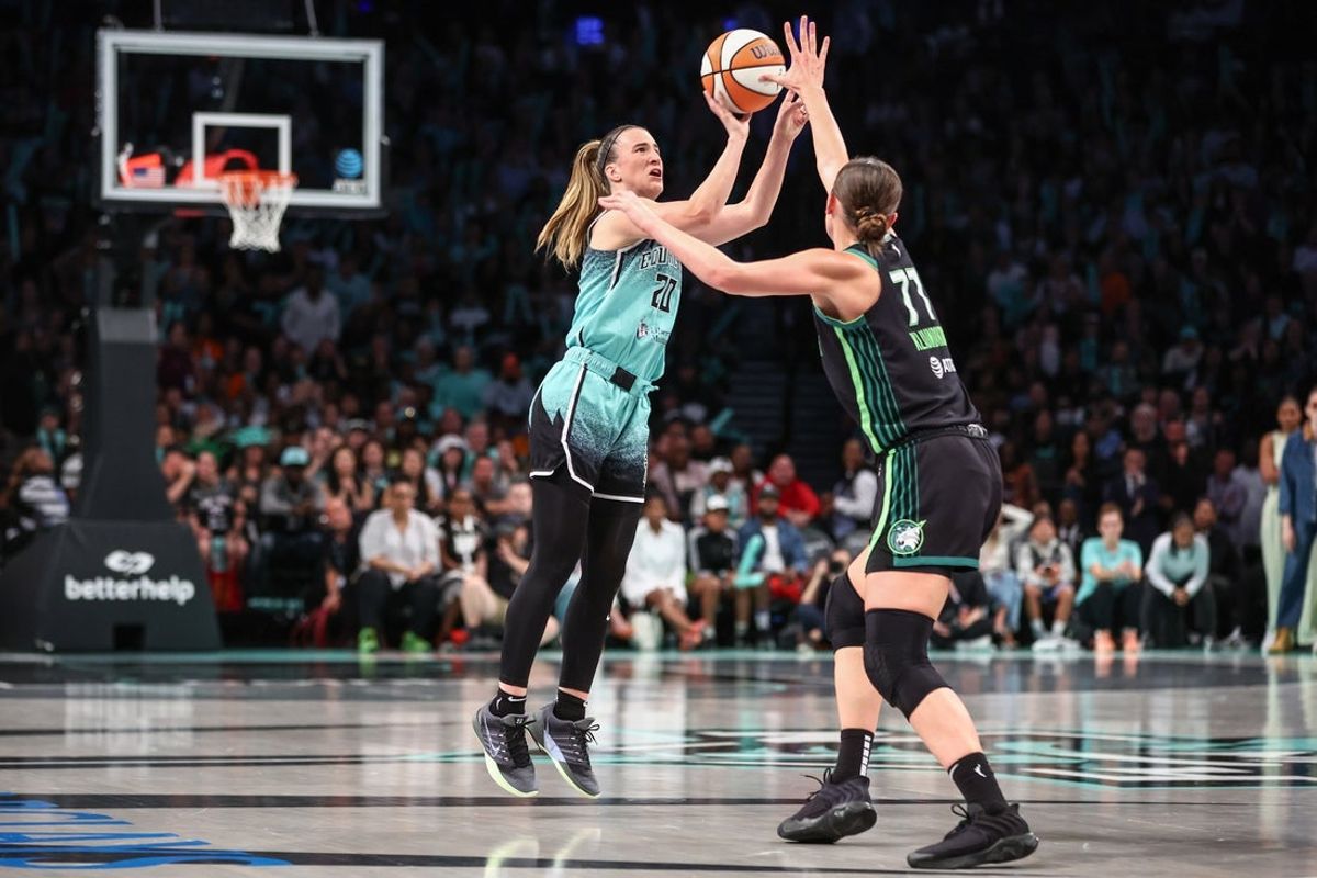 Aug 19, 2025; Brooklyn, New York, USA;  New York Liberty guard Sabrina Ionescu (20) takes a three point shot past Minnesota Lynx forward Maria Kliundikova (77) in the fourth quarter at Barclays Center. Mandatory Credit: Wendell Cruz-Imagn Images