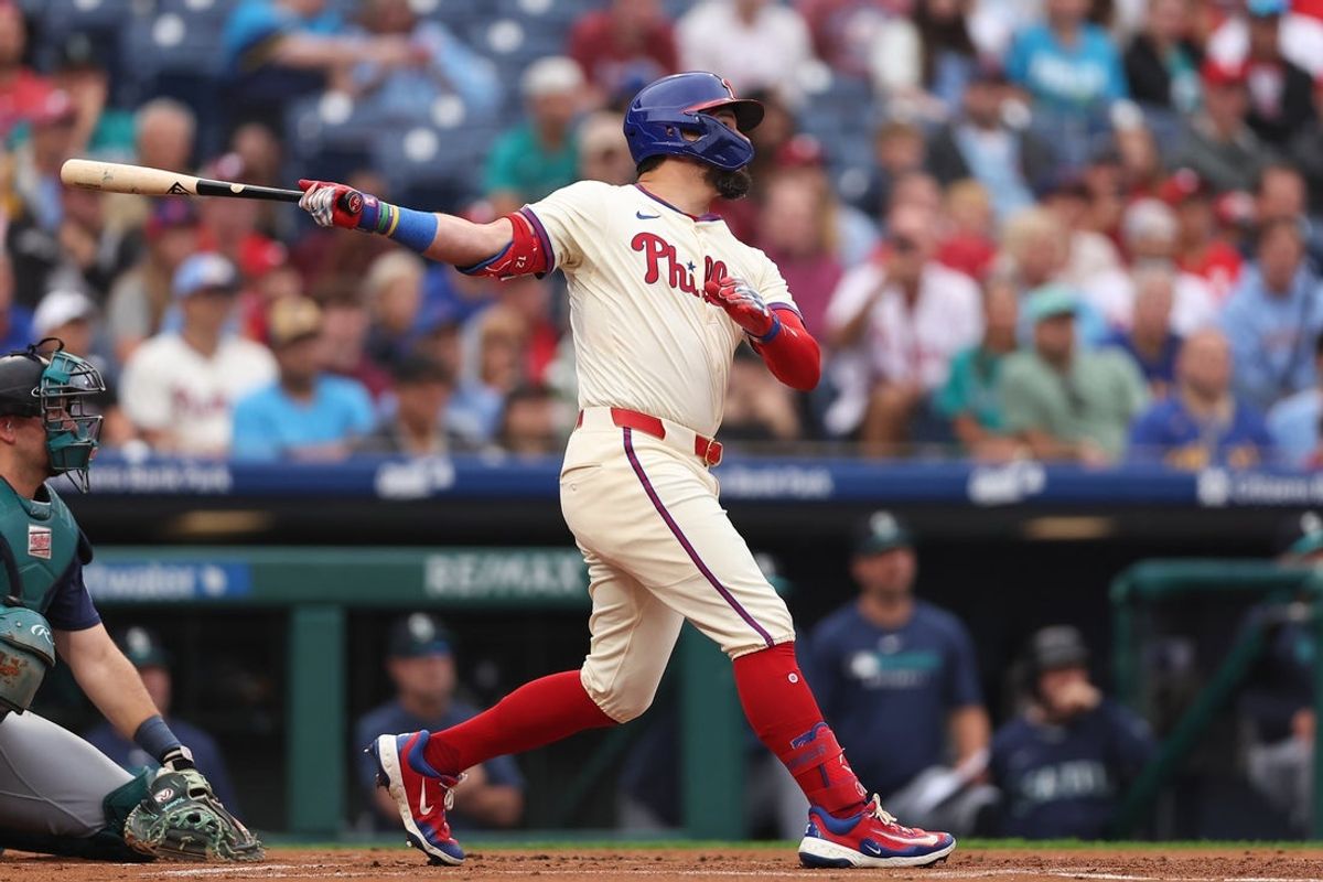 Aug 20, 2025; Philadelphia, Pennsylvania, USA; Philadelphia Phillies outfielder Kyle Schwarber (12) hits an RBI sacrifice fly during the first inning against the Seattle Mariners at Citizens Bank Park. Mandatory Credit: Bill Streicher-Imagn Images
