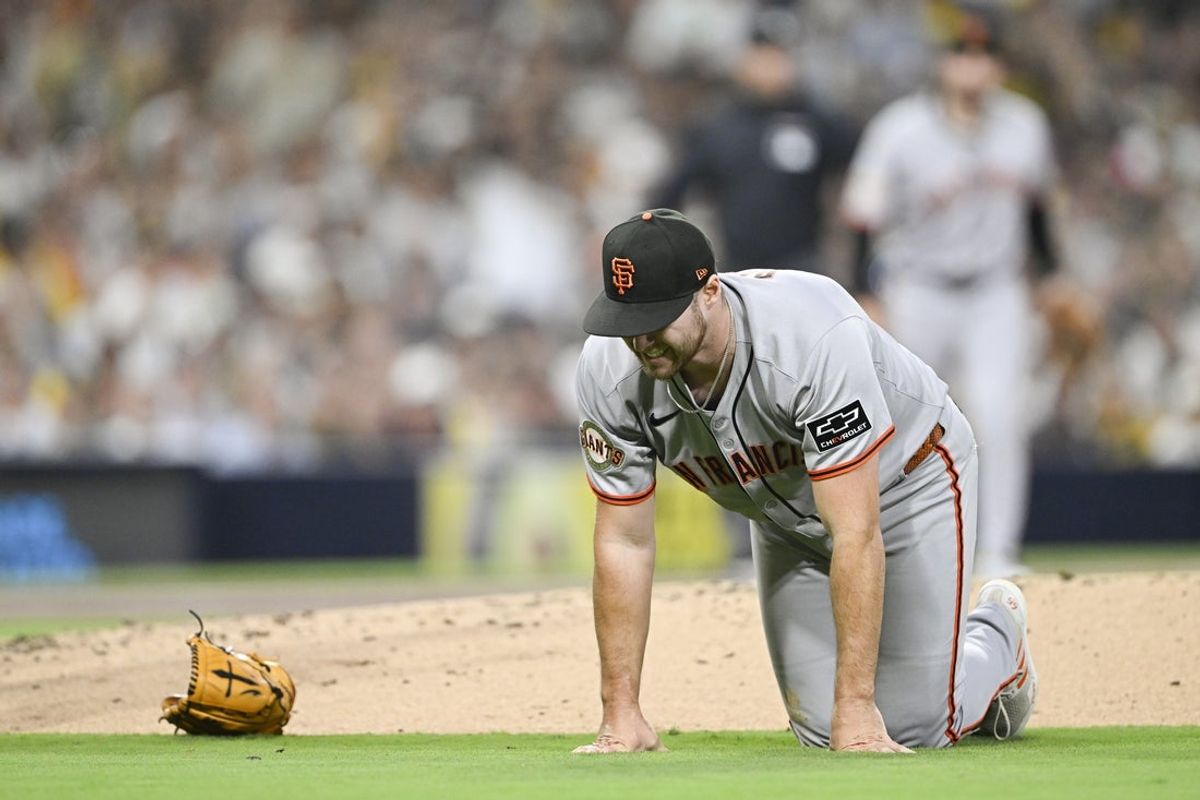 Aug 20, 2025; San Diego, California, USA; San Francisco Giants starting pitcher Landen Roupp (65) goes down to the ground after being hit by a ball hit by San Diego Padres right fielder Ramon Laureano (5) during the third inning at Petco Park. Mandatory Credit: Denis Poroy-Imagn Images