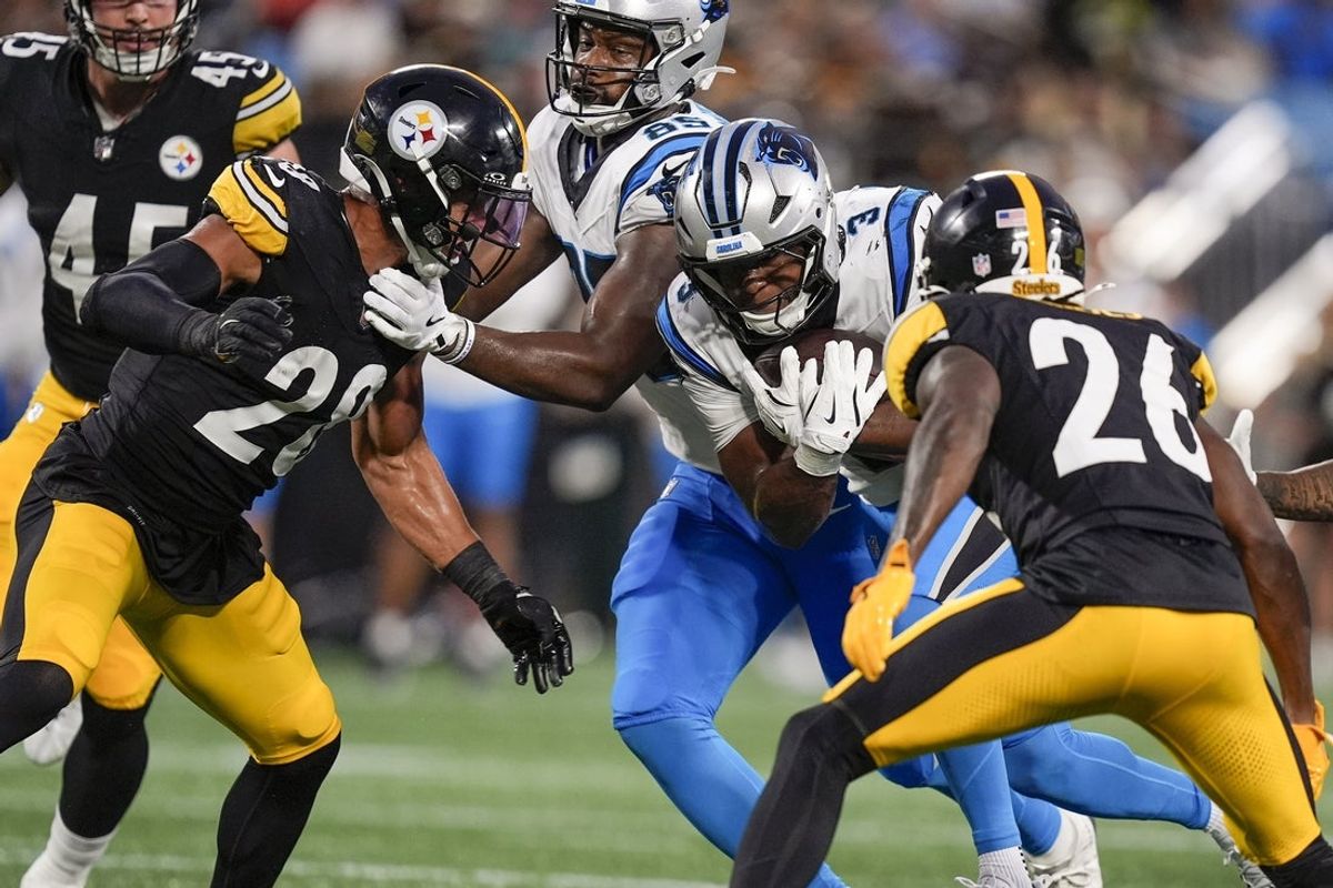 Aug 21, 2025; Charlotte, North Carolina, USA; Carolina Panthers running back Raheem Blackshear (3) is tackled by Pittsburgh Steelers cornerback Brandin Echols (26) and safety Miles Killebrew (28) during the second quarter at Bank of America Stadium. Mandatory Credit: Jim Dedmon-Imagn Images