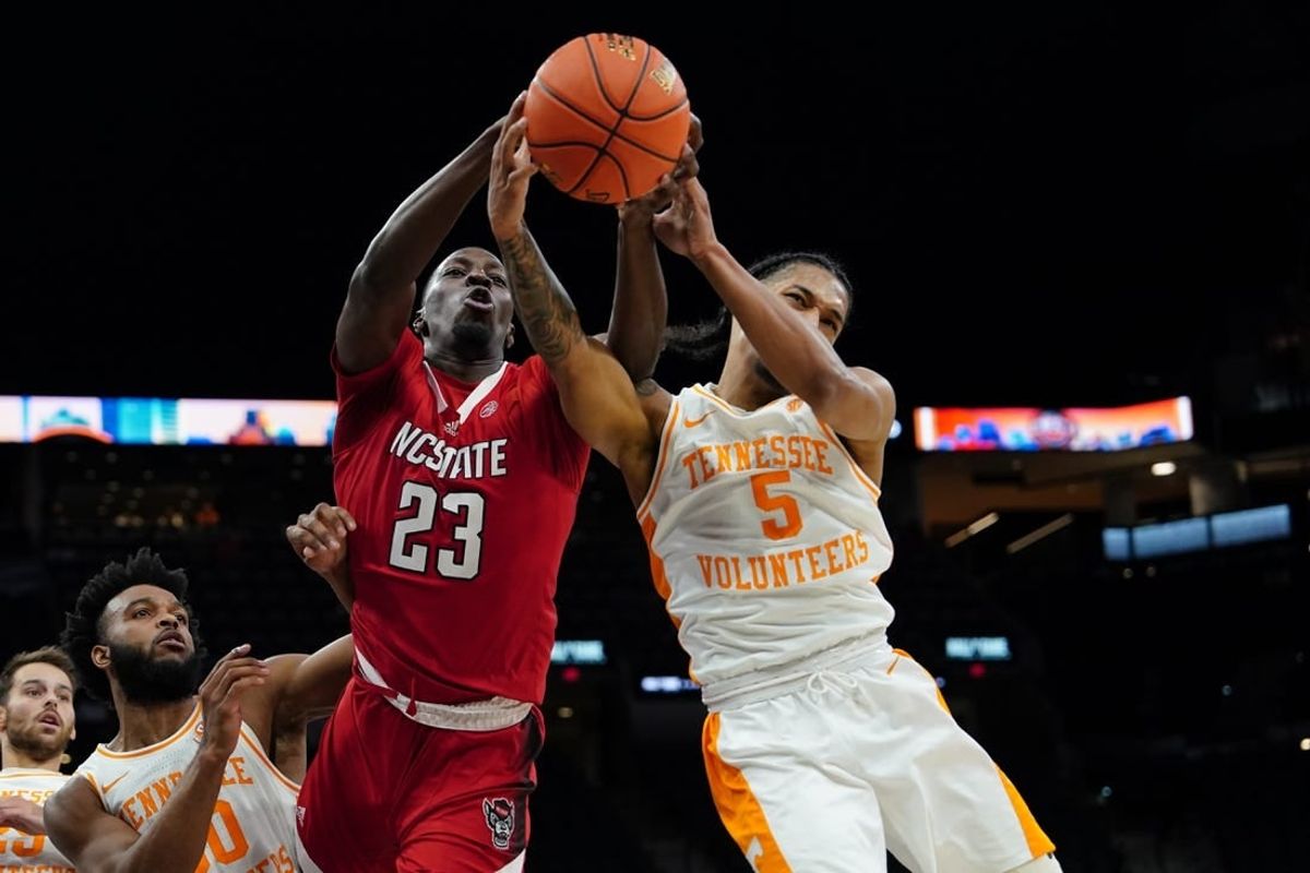 Dec 16, 2023; San Antonio, Texas, USA;  North Carolina State Wolfpack forward Mohamed Diarra (23) and Tennessee Volunteers guard Zakai Zeigler (5) go after the ball in the first half at the Frost Bank Center.