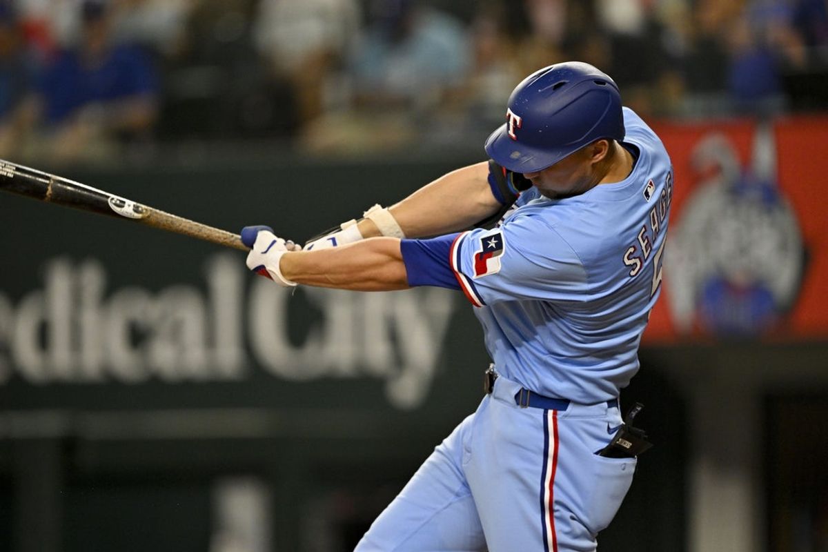 Aug 24, 2025; Arlington, Texas, USA; Texas Rangers shortstop Corey Seager (5) hits a single during the third inning against the Cleveland Guardians at Globe Life Field. Mandatory Credit: Jerome Miron-Imagn Images