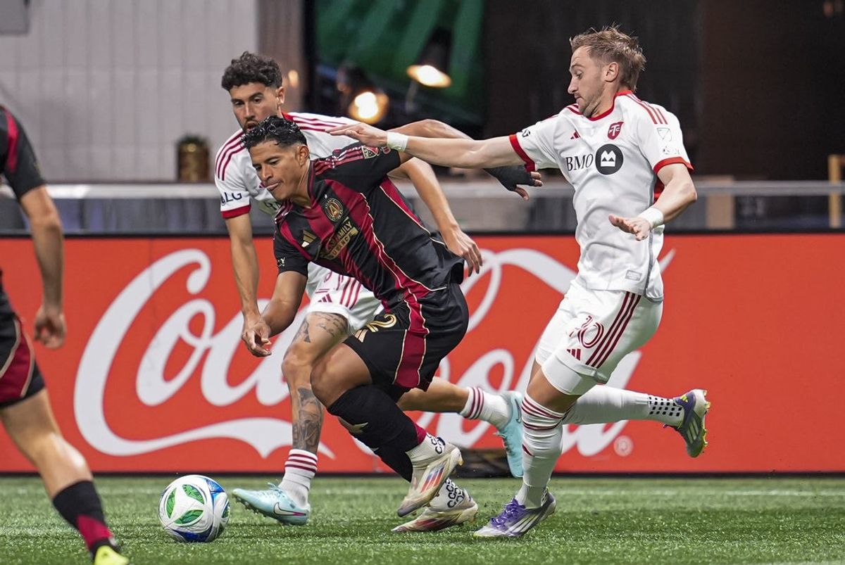 Aug 24, 2025; Atlanta, Georgia, USA; Atlanta United defender Ronald Hernandez (2) and Toronto FC midfielder Djordje Mihailovic (10) fight for the ball during the first half at Mercedes-Benz Stadium. Mandatory Credit: Dale Zanine-Imagn Images