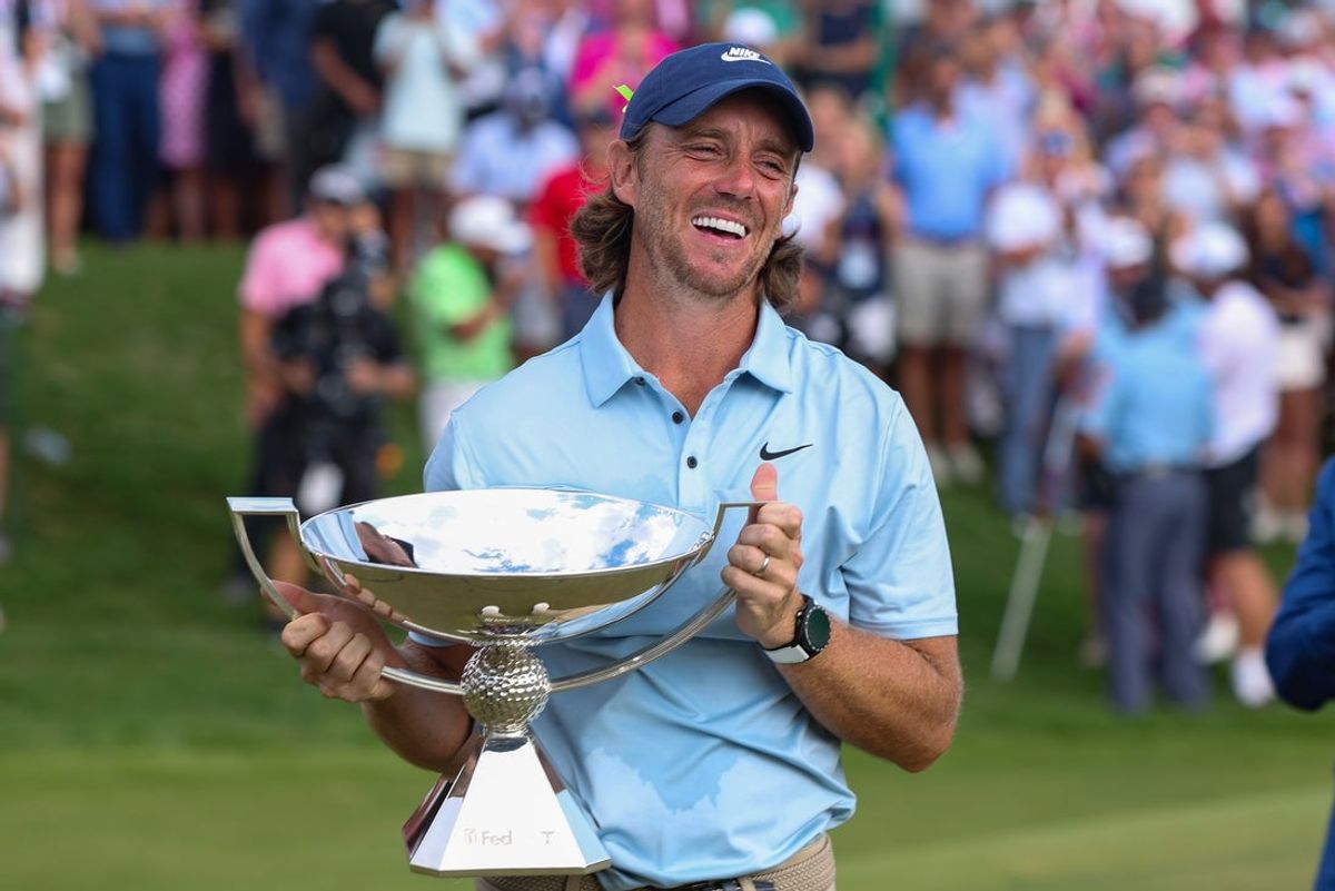 Aug 24, 2025; Atlanta, Georgia, USA; Tommy Fleetwood holds the FedExCup Trophy on the 18th green after winning the TOUR Championship golf tournament. Mandatory Credit: Brett Davis-Imagn Images