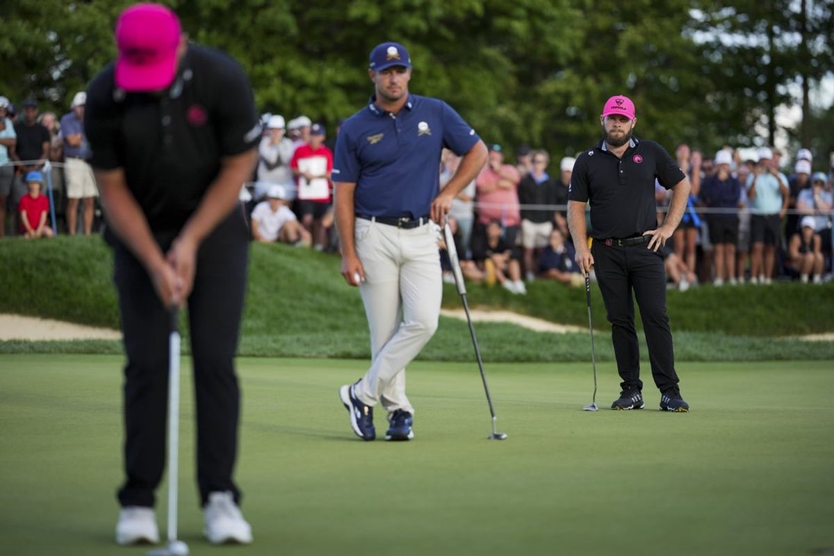Aug 24, 2025; Detroit, Michigan, USA; Tyrrell Hatton of Legion XIII and Bryson DeChambeau of Crushers GC watch as Jon Rahm of Legion XIII putts on the 18th green in a playoff hole during the finals of the LIV Golf Michigan Team Championship at The Cardinal at Saint John's Resort. Mandatory Credit: Aaron Doster-Imagn Images