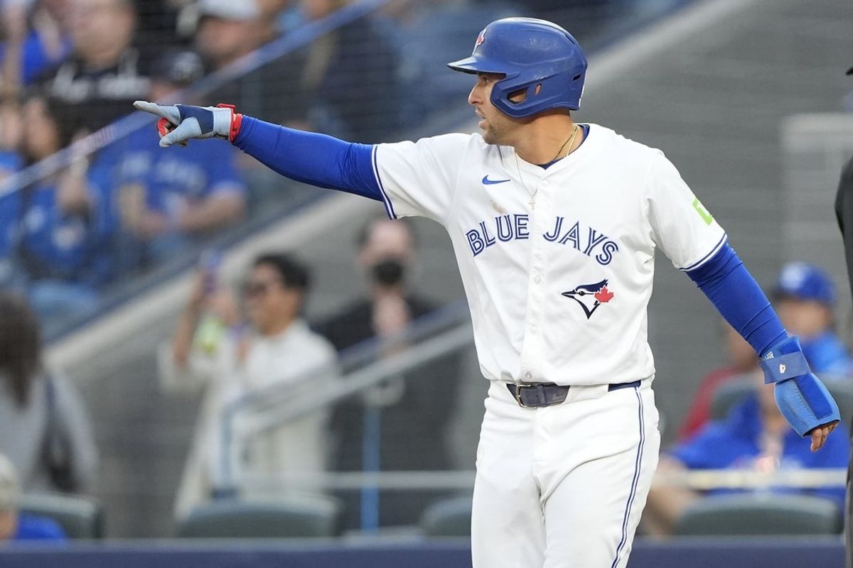 Aug 25, 2025; Toronto, Ontario, CAN; Toronto Blue Jays left fielder George Springer (4) gestures to shortstop Bo Bichette (not pictured) after scoring on his single against the Minnesota Twins during the first inning at Rogers Centre. Mandatory Credit: John E. Sokolowski-Imagn Images