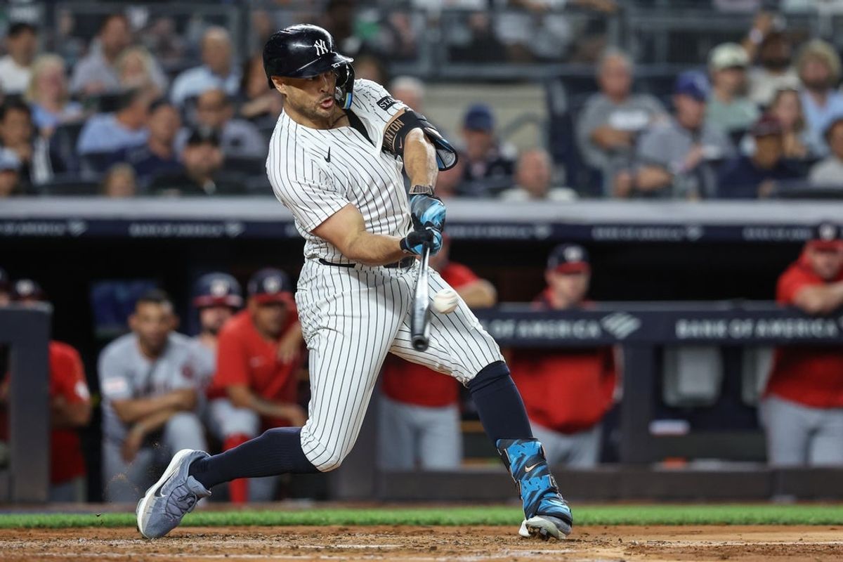 Aug 26, 2025; Bronx, New York, USA;  New York Yankees right fielder Giancarlo Stanton (27) hits a three run double in the third inning against the Washington Nationals at Yankee Stadium. Mandatory Credit: Wendell Cruz-Imagn Images
