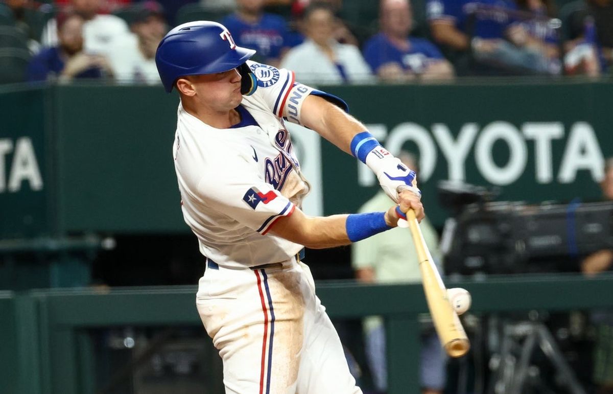 Aug 26, 2025; Arlington, Texas, USA; Texas Rangers third baseman Josh Jung (6) hits an rbi single against the Los Angeles Angels during the first inning at Globe Life Field. Mandatory Credit: Kevin Jairaj-Imagn Images
