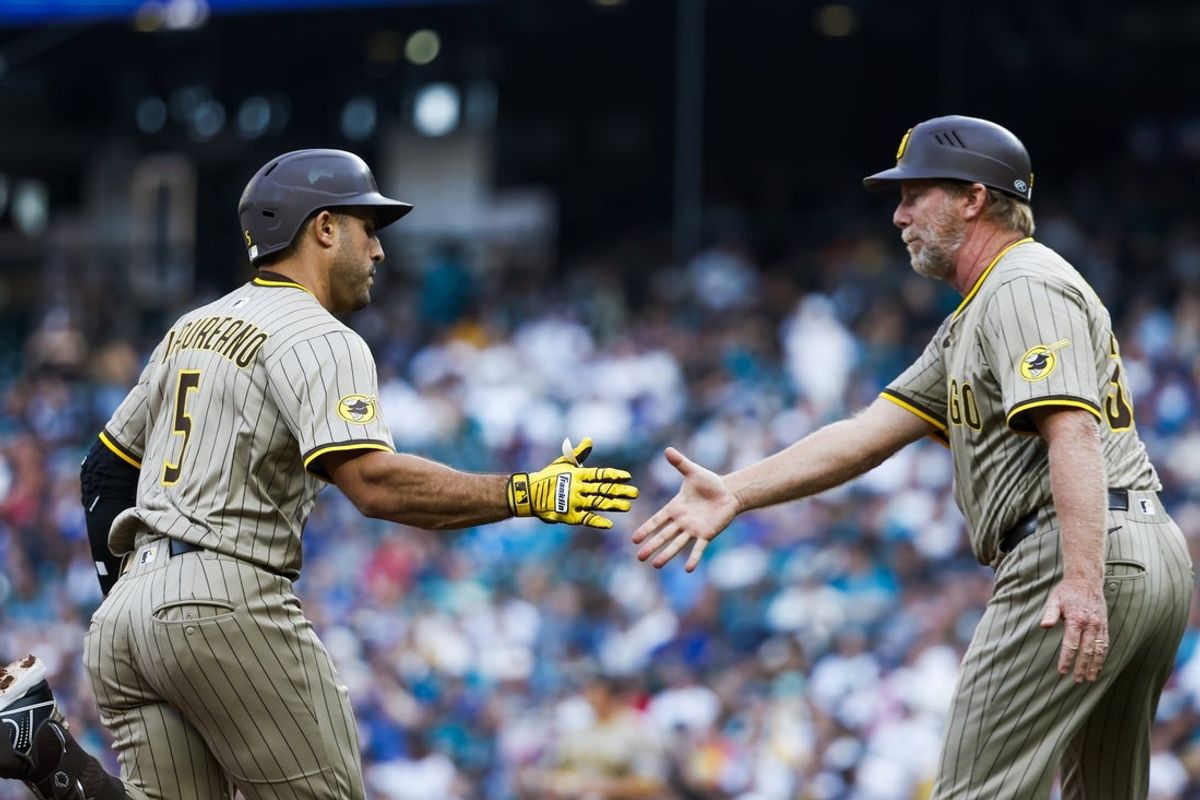 Aug 26, 2025; Seattle, Washington, USA; San Diego Padres center fielder Ramón Laureano (5) shakes hands with third base coach Tim Leiper (33) after hitting a grand-slam home run against the Seattle Mariners during the first inning at T-Mobile Park. Mandatory Credit: Joe Nicholson-Imagn Images