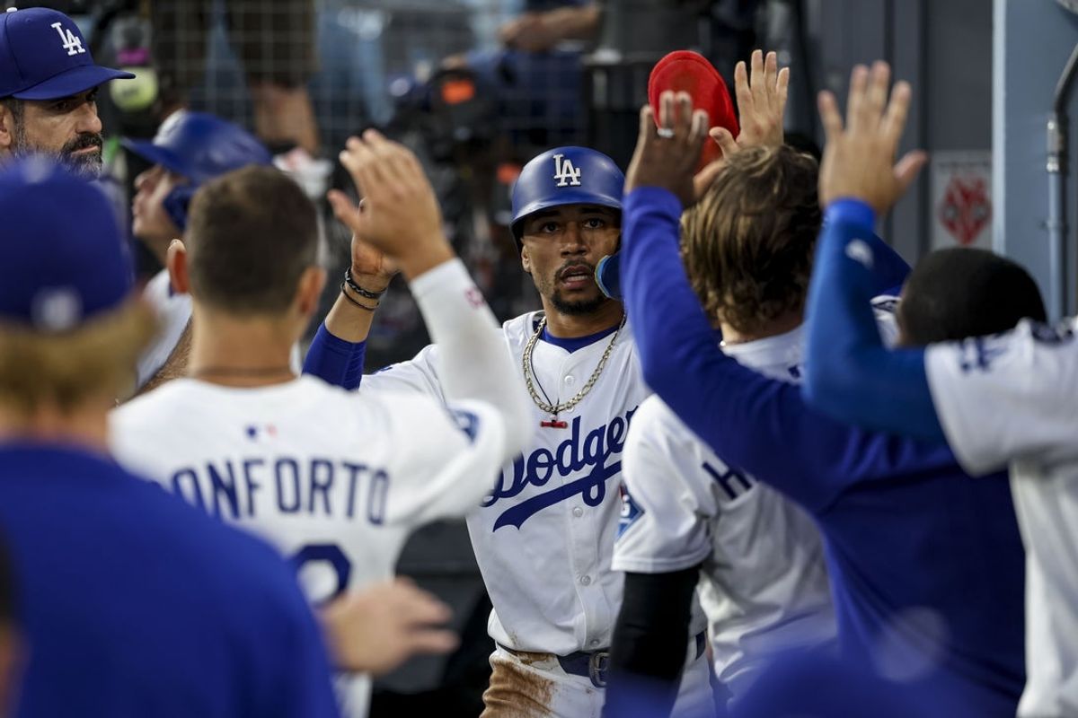 Aug 26, 2025; Los Angeles, California, USA; Los Angeles Dodgers shortstop Mookie Betts (50) is greeted in the dugout after scoring a run during the first inning at Dodger Stadium. Mandatory Credit: Kiyoshi Mio-Imagn Images