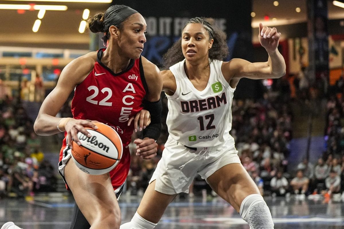 Aug 27, 2025; College Park, Georgia, USA; Las Vegas Aces center A'ja Wilson (22) dribbles against Atlanta Dream forward Nia Coffey (12) during the first half at Gateway Center Arena at College Park. Mandatory Credit: Dale Zanine-Imagn Images