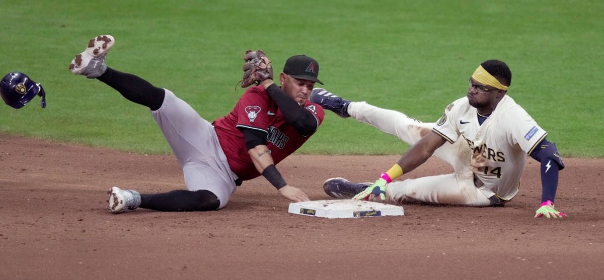 Milwaukee Brewers shortstop Andruw Monasterio (14) is tagged by Arizona Diamondbacks second base Ildemaro Vargas (6) during the ninth inning of their game Wednesday, August 27, 2025 at American Family Field in Milwaukee, Wisconsin.