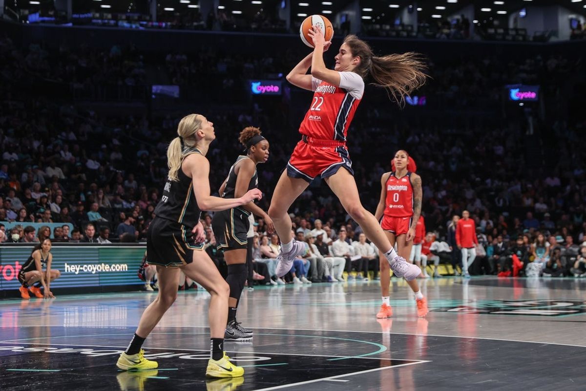 Aug 28, 2025; Brooklyn, New York, USA;  Washington Mystics guard Sonia Citron (22) leaps to make a pass over New York Liberty guard Marine Johannes (23) in the second quarter at Barclays Center. Mandatory Credit: Wendell Cruz-Imagn Images