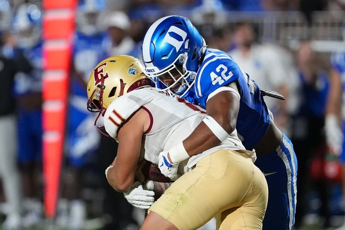 Aug 28, 2025; Durham, North Carolina, USA;  Duke Blue Devils linebacker Kendall Johnson (42) stops the run by Elon Phoenix quarterback Landen Clark (11) during the first half at Wallace Wade Stadium. Mandatory Credit: James Guillory-Imagn Images