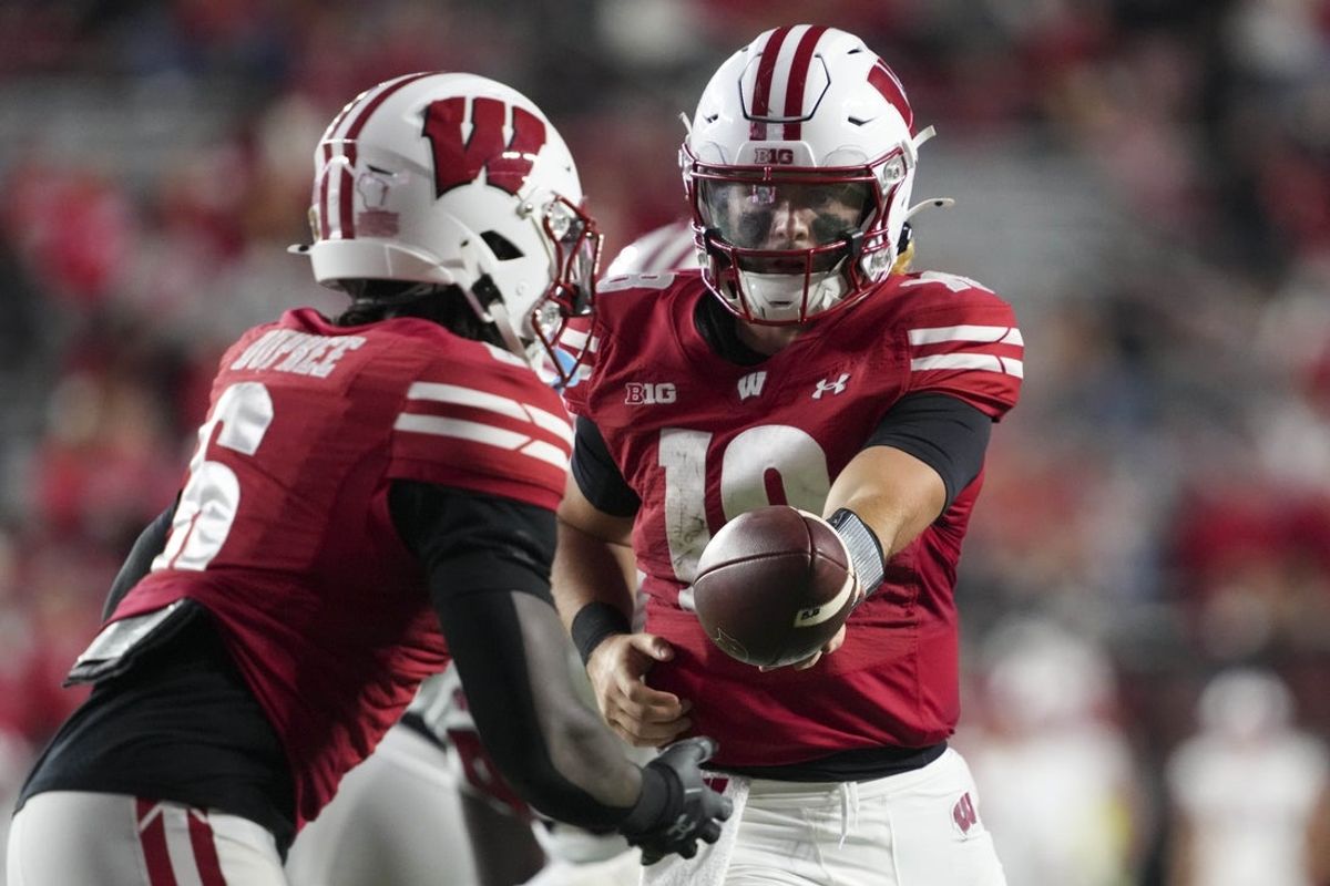 Aug 28, 2025; Madison, Wisconsin, USA;  Wisconsin Badgers quarterback Danny O'Neil (18) hands the football off to running back Darrion Dupree (6) during the fourth quarter against the Miami (OH) RedHawks at Camp Randall Stadium. Mandatory Credit: Jeff Hanisch-Imagn Images