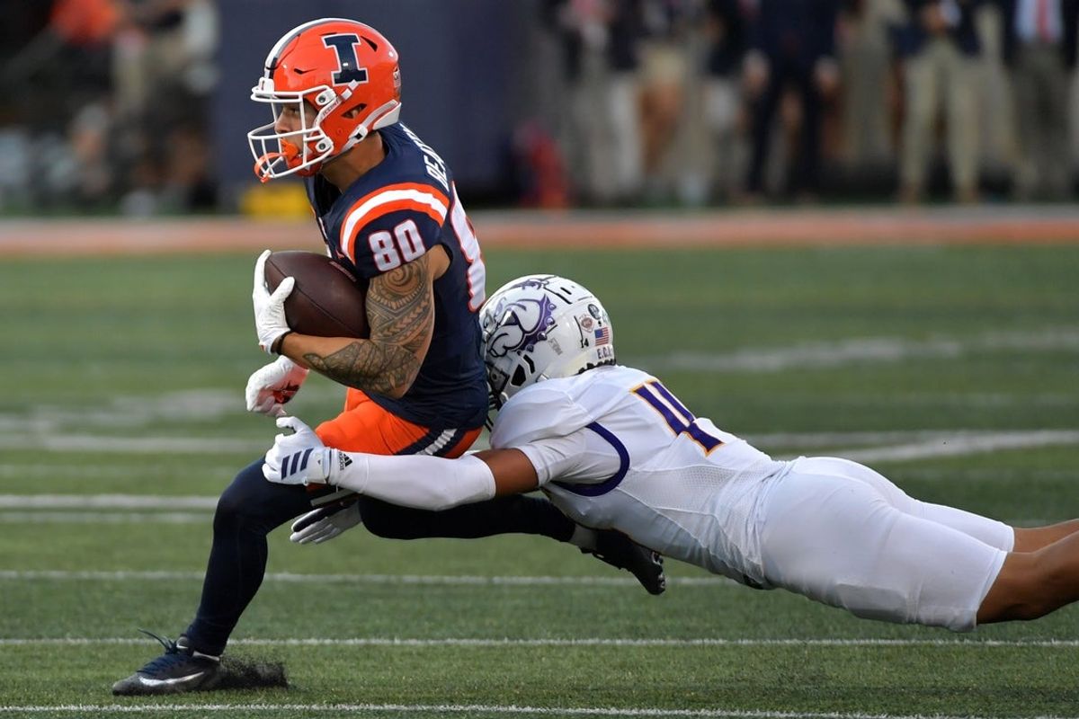 Aug 29, 2025; Champaign, Illinois, USA;  Illinois Fighting Illini wide receiver Hank Beatty (80) runs the ball after a pass reception as Western Illinois Leathernecks defensive back Buju Aumua-Tuisavura (14) tackles during the first half at Memorial Stadium. Mandatory Credit: Ron Johnson-Imagn Images