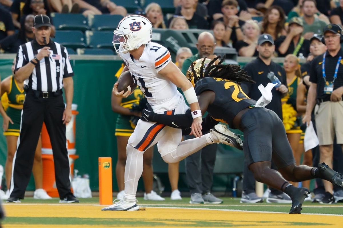 Aug 29, 2025; Waco, Texas, USA;  Auburn Tigers quarterback Jackson Arnold (11) runs the ball for a touchdown against Baylor Bears cornerback Calvin Simpson-Hunt (28) during the first half at McLane Stadium. Mandatory Credit: Chris Jones-Imagn Images