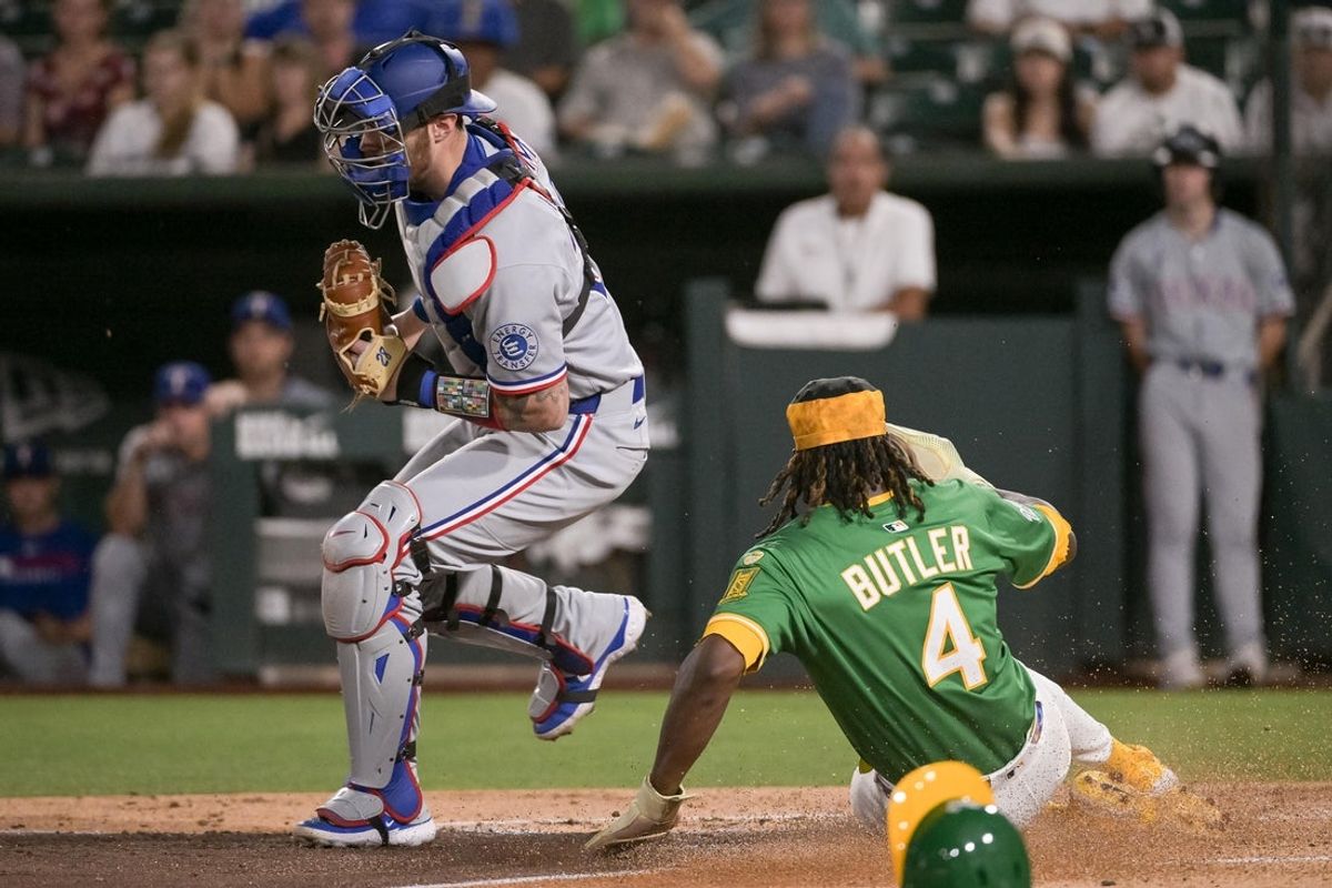 Aug 29, 2025; West Sacramento, California, USA; Texas Rangers catcher Jonah Heim (28) completes the force out at home plate against Athletics outfielder Lawrence Butler (4) during the third inning at Sutter Health Park. Mandatory Credit: Ed Szczepanski-Imagn Images