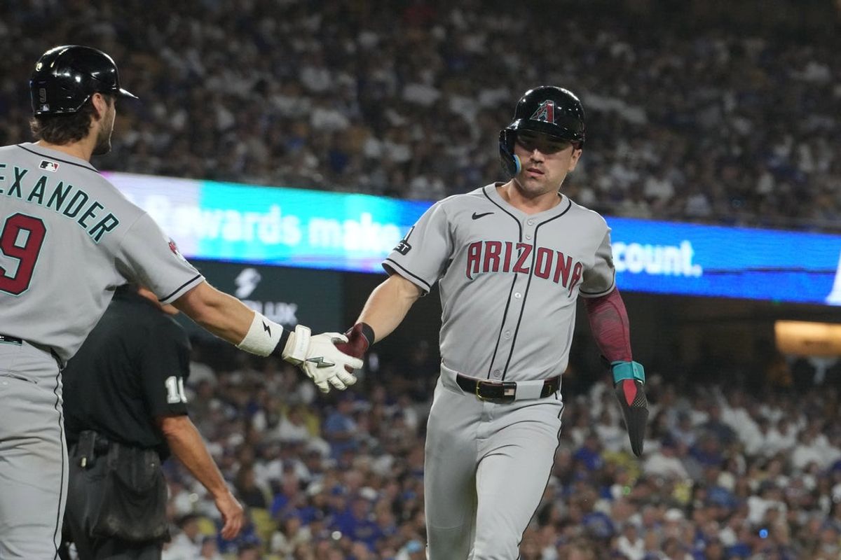 Aug 29, 2025; Los Angeles, California, USA; Arizona Diamondbacks right fielder Corbin Carroll (7) is congratulated by second baseman Blaze Alexander (9) after scoring in the sixth inning against the Los Angeles Dodgers at Dodger Stadium. Mandatory Credit: Kirby Lee-Imagn Images