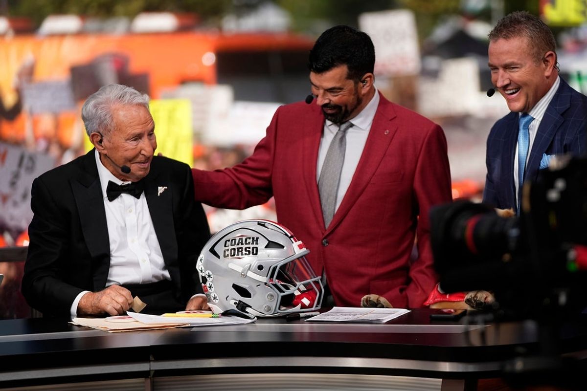 Ohio State Buckeyes head coach Ryan Day presents Lee Corso with a helmet beside Kirk Herbstreit on the set of ESPN College GameDay prior to the NCAA football game between the Ohio State Buckeyes and the Texas Longhorns at Ohio Stadium on Aug. 30, 2025.