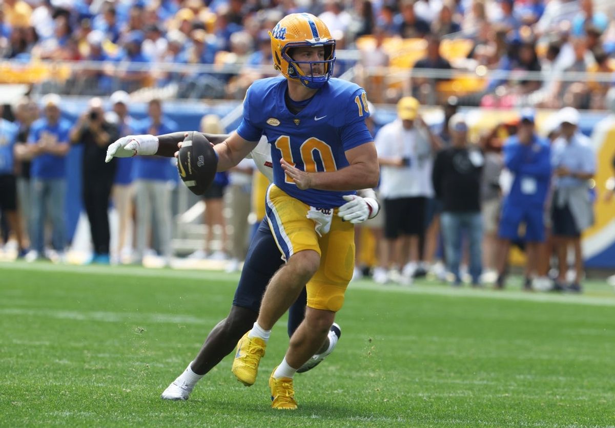 Aug 30, 2025; Pittsburgh, Pennsylvania, USA; Pittsburgh Panthers quarterback Eli Holstein (10) looks to pass under pressure from Duquesne Dukes defensive lineman Ish Findlayter (rear) during the second quarter at Acrisure Stadium. Mandatory Credit: Charles LeClaire-Imagn Images