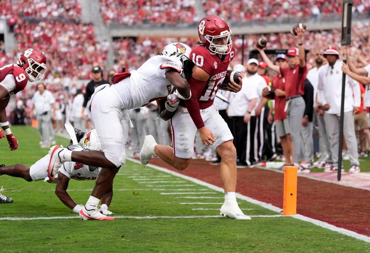 Oklahoma's John Mateer (10) scores a touchdown as Illinois State's La'Shavion Brown (4) defends in the first half of the college football game between the University of Oklahoma Sooners and the Illinois State Redbirds at the Gaylord Family Oklahoma Memorial Stadium in Norman, Okla., Saturday, Aug. 30, 2025.