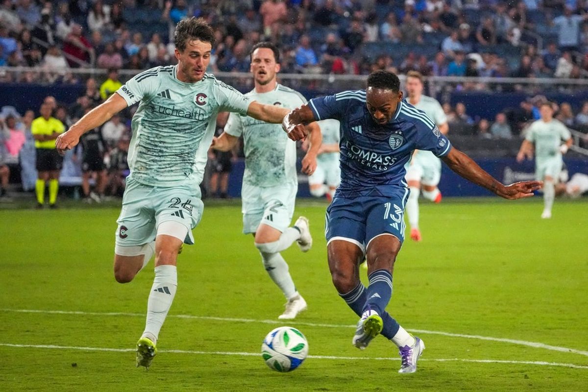 Aug 30, 2025; Kansas City, Kansas, USA; Sporting Kansas City forward Mason Toye (13) kicks the ball as Colorado Rapids defender Noah Cobb (24) defends during the second half of the game at Children's Mercy Park. Mandatory Credit: Denny Medley-Imagn Images