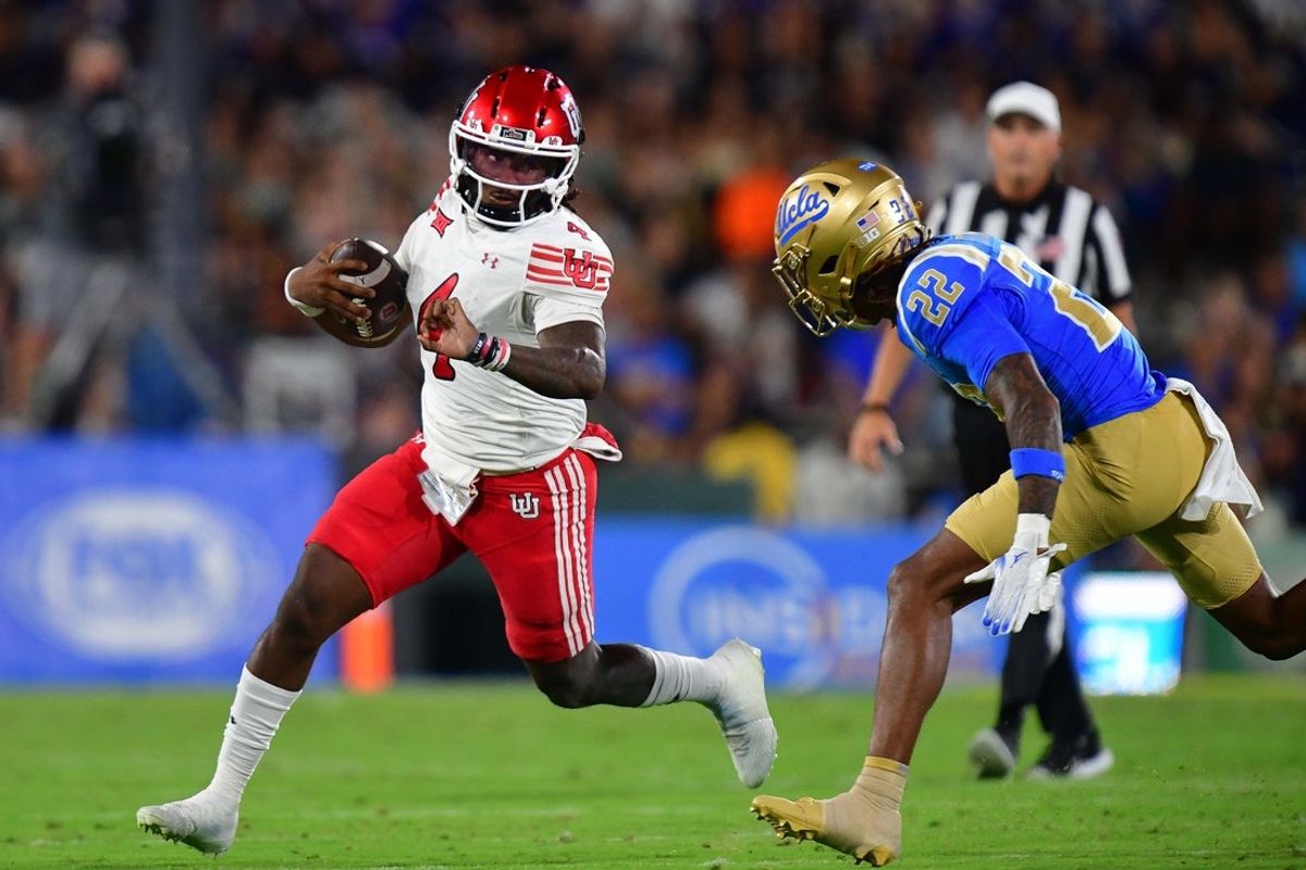 Aug 30, 2025; Pasadena, California, USA; Utah Utes quarterback Devon Dampier (4) runs the ball against UCLA Bruins defensive back Croix Stewart (22) during the first half at Rose Bowl. Mandatory Credit: Gary A. Vasquez-Imagn Images