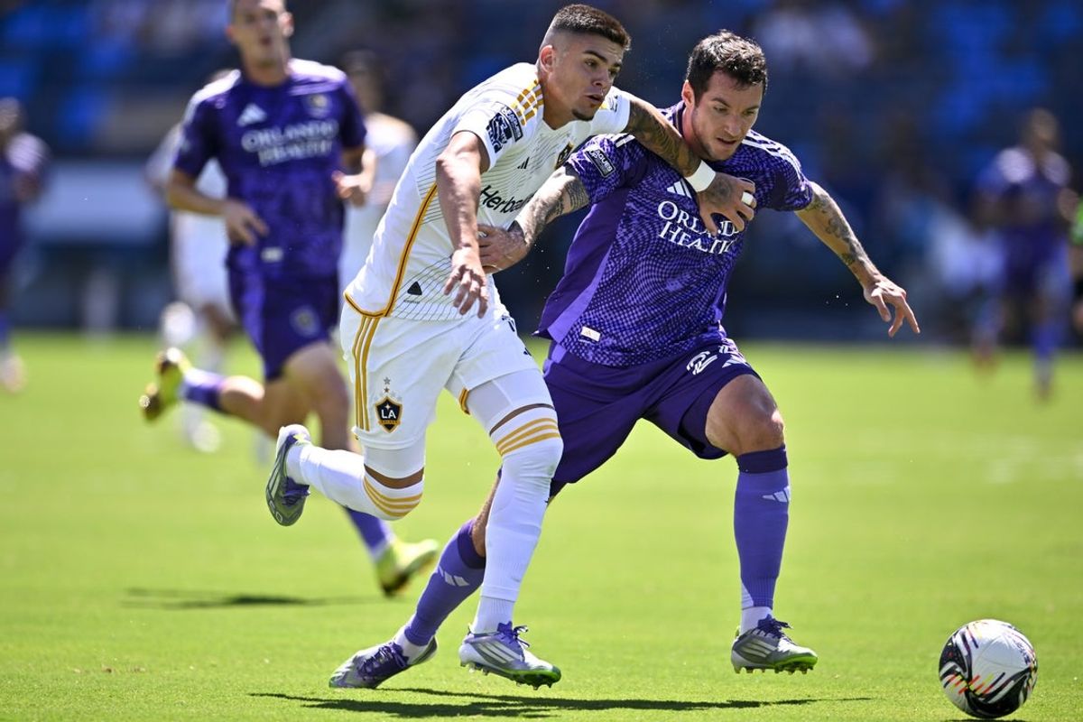 Aug 31, 2025; Carson, California, USA; LA Galaxy forward Gabriel Pec (11) moves the ball past Orlando City SC defender Kyle Smith (24) for an assist to midfielder Marco Reus (18) during the first half at Dignity Health Sports Park. Mandatory Credit: Kelvin Kuo-Imagn Images