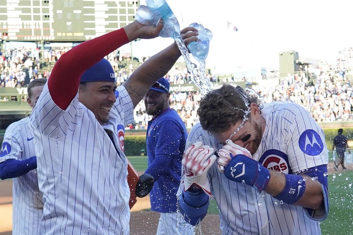 Sep 1, 2025; Chicago, Illinois, USA;  Chicago Cubs catcher Carson Kelly (15) is doused with water  from pitcher Daniel Palencia (48) after hitting a game winning single against the Atlanta Braves at Wrigley Field. Mandatory Credit: David Banks-Imagn Images