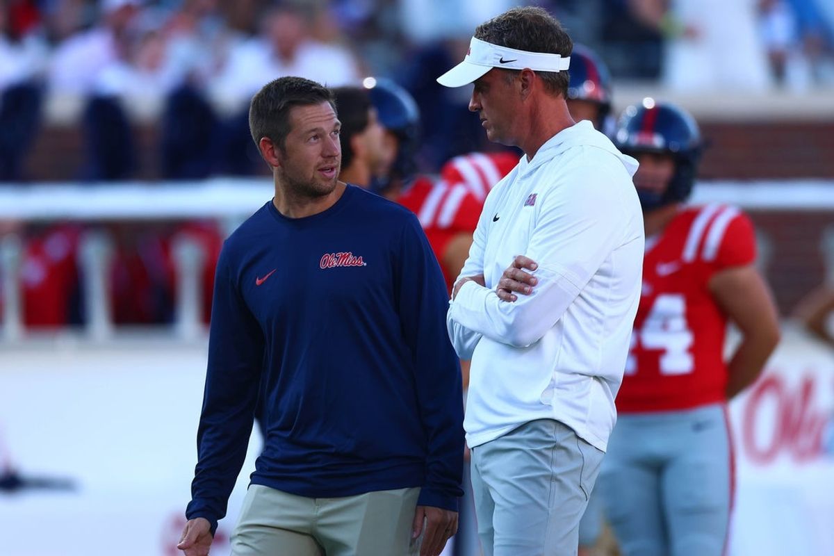 Aug 30, 2025; Oxford, Mississippi, USA; Mississippi Rebels head coach Lane Kiffin (right) talks with offensive coordinator Charlie Weis Jr. during warm ups prior to the game against the Georgia State Panthers at Vaught-Hemingway Stadium. Mandatory Credit: Petre Thomas-Imagn Images