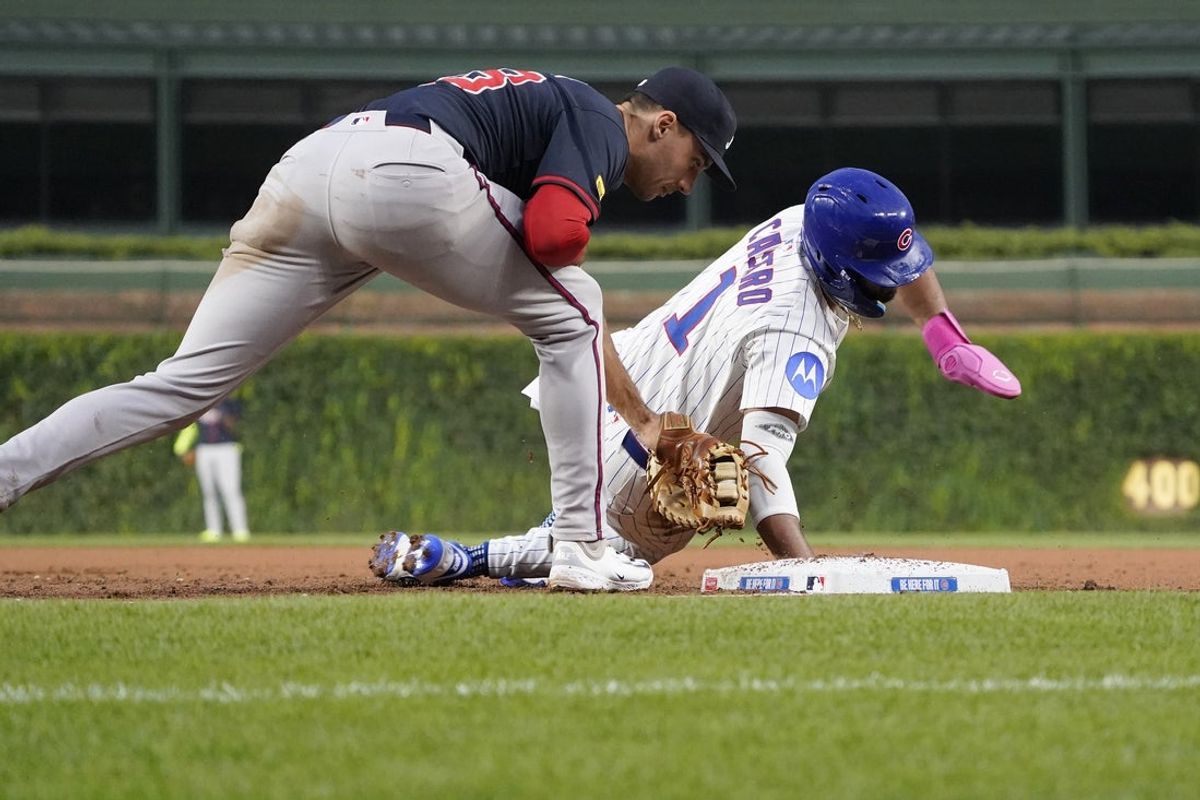 Sep 3, 2025; Chicago, Illinois, USA; Chicago Cubs outfielder Willi Castro (1) dives safely back into first base as Atlanta Braves first base Matt Olson (28) makes a late tag during the second inning at Wrigley Field. Mandatory Credit: David Banks-Imagn Images