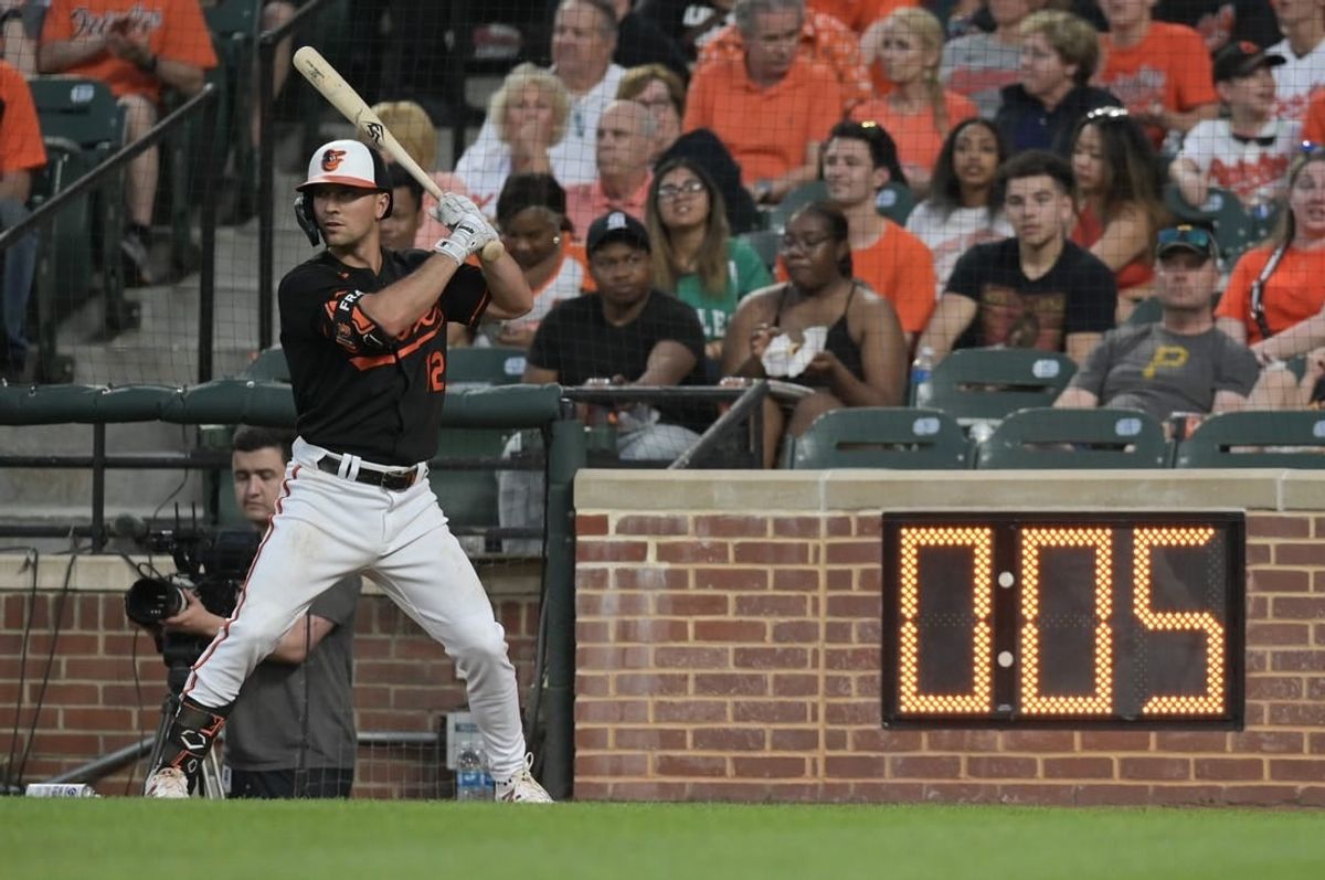 May 12, 2023; Baltimore, Maryland, USA;  Baltimore Orioles second baseman Adam Frazier (12) warms up next to the pitch clock during the third inning of the game against the Pittsburgh Pirates at Oriole Park at Camden Yards.