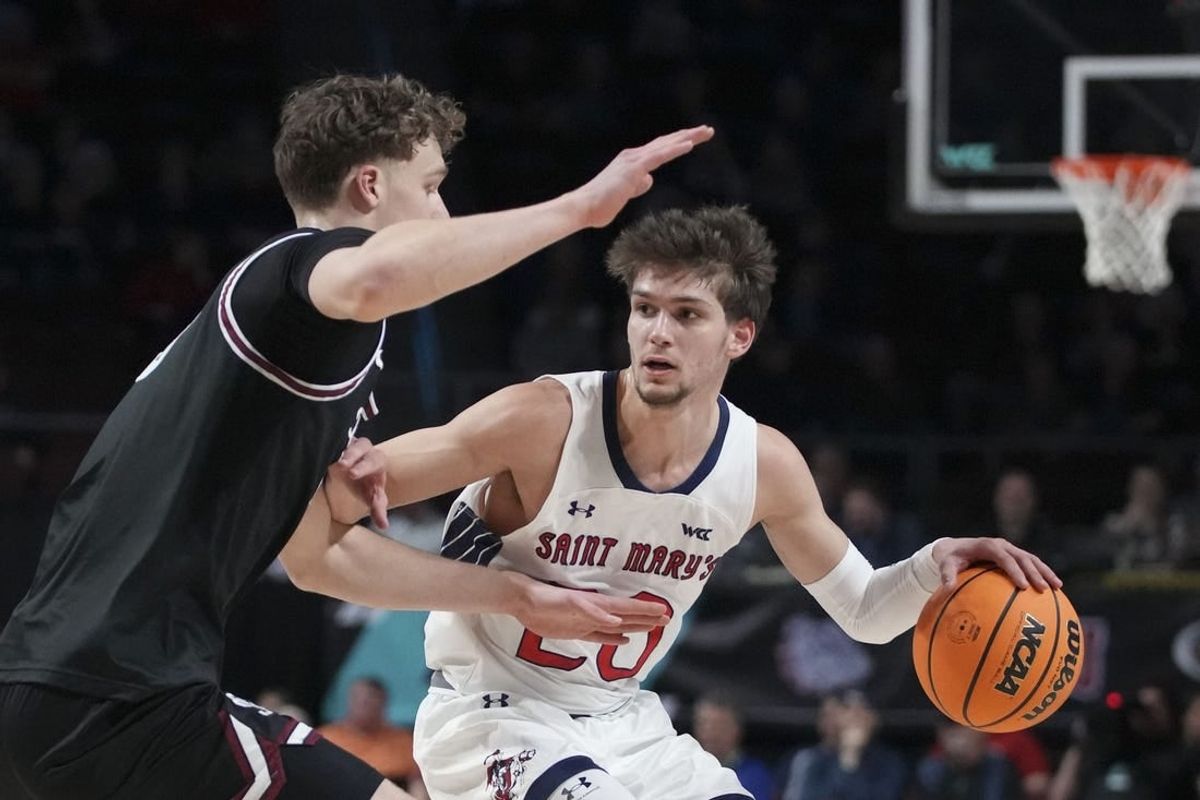 March 11, 2024; Las Vegas, NV, USA; Saint Mary's Gaels guard Aidan Mahaney (20) dribbles the basketball against Santa Clara Broncos center Christoph Tilly (13) during the first half in the semifinals of the WCC Basketball Championship at Orleans Arena.